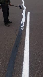 Close up of a rubber filled crack at Kohls parking lot